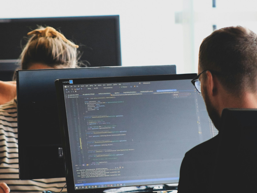 Employés de Pandata Services devant des écrans d'ordinateur en train de configurer des équipements informatiques pour artisans et entrepreneurs